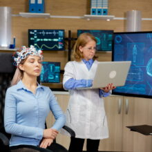 GSES-Doctor analyzing live data on a laptop during a girl's brain scan procedure